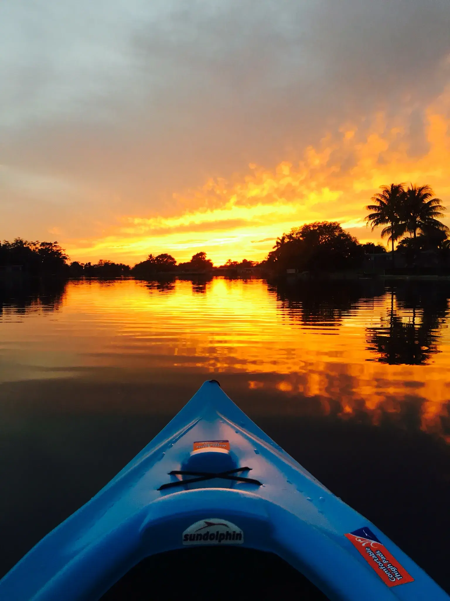 The bow of Gurpreet’s kayak pointing toward a vivid Florida sunset reflected across the lake in March 2016