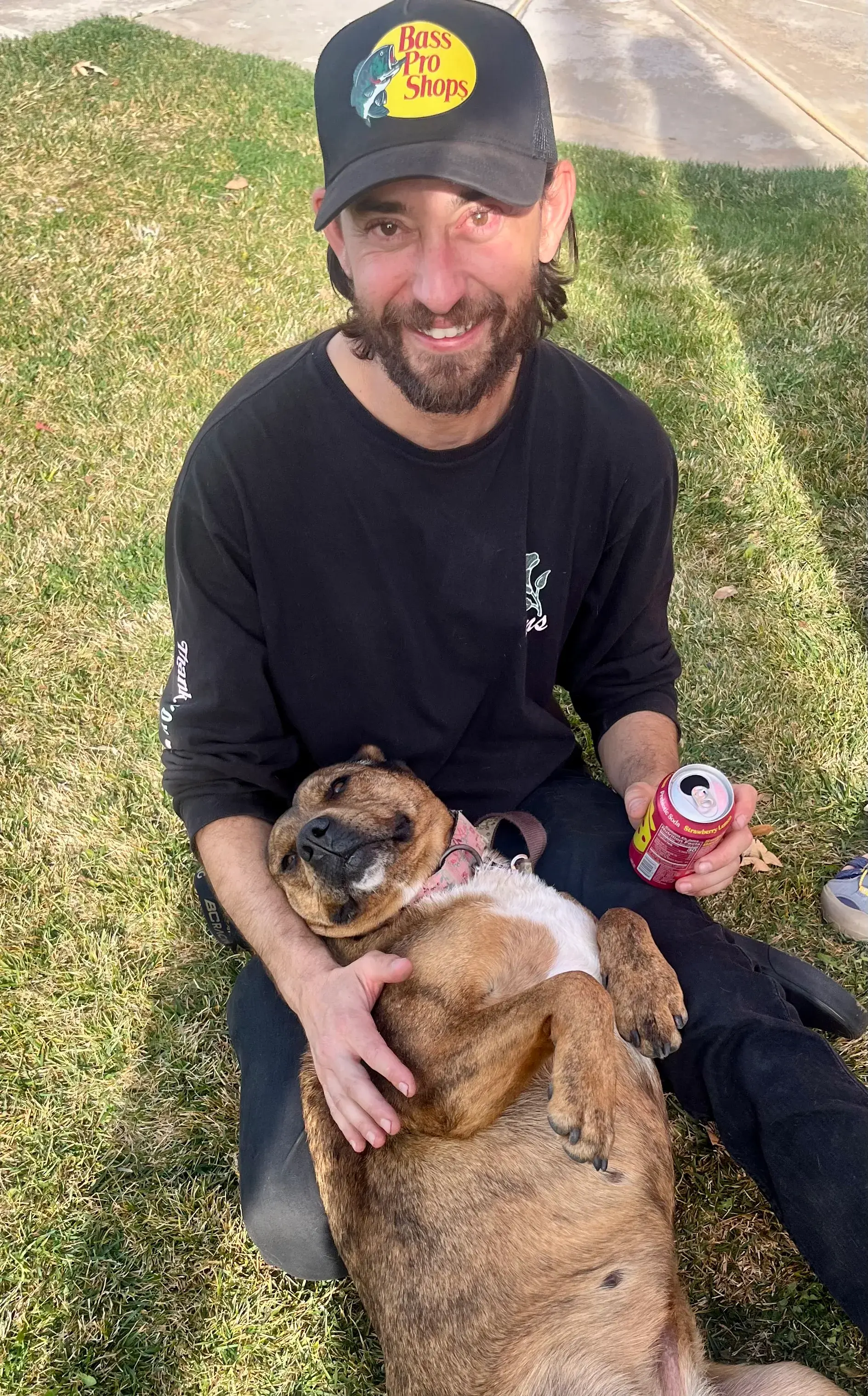 A Pizza for Paws guest holding a relaxed rescue dog at the event