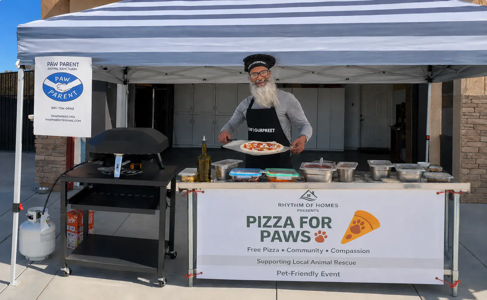 Gurpreet holding a pizza peel at the complete Pizza for Paws station alongside Paw Parent signage