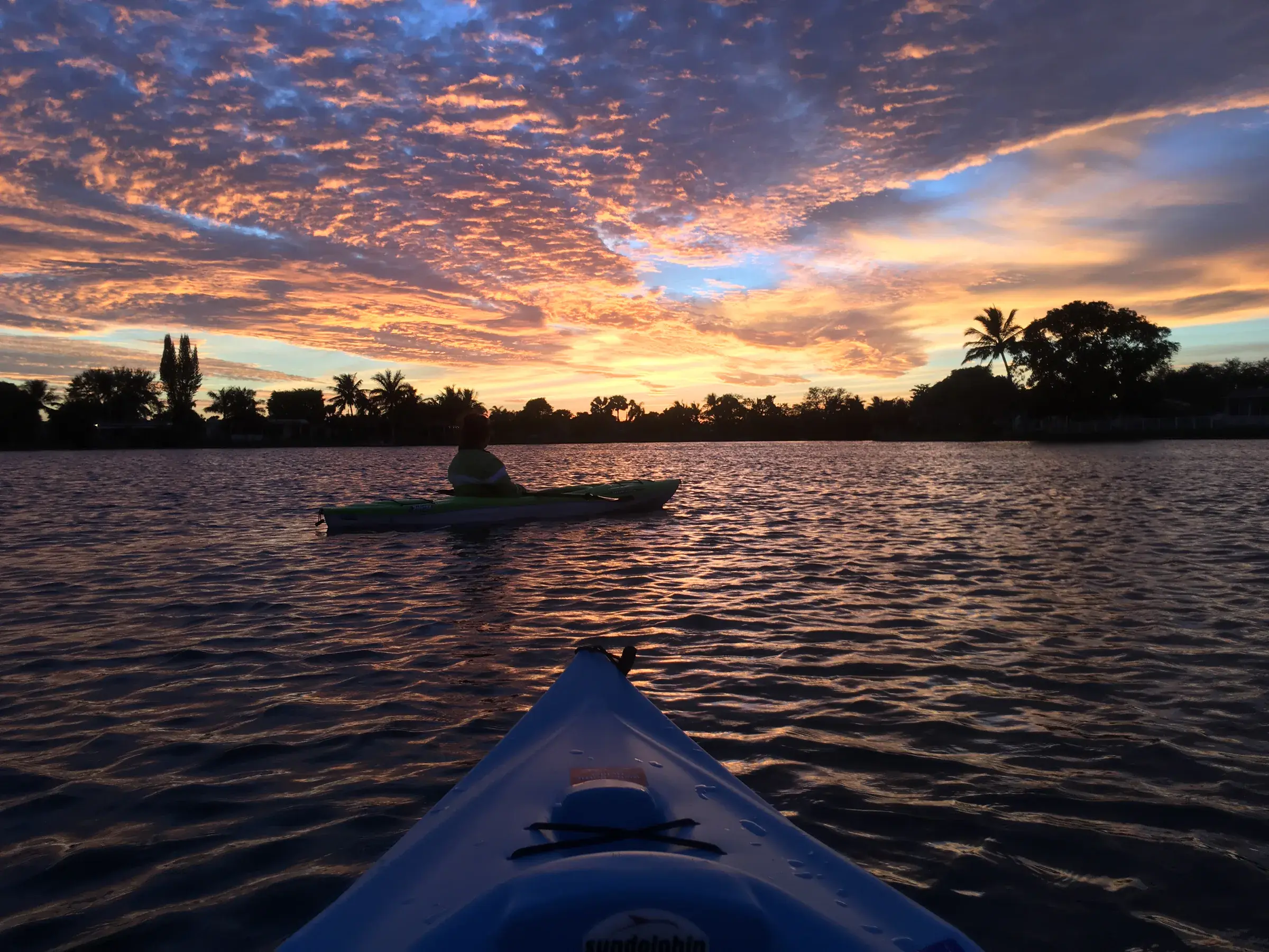 Kayaking together on a Florida lake beneath a vivid sunset in December 2016