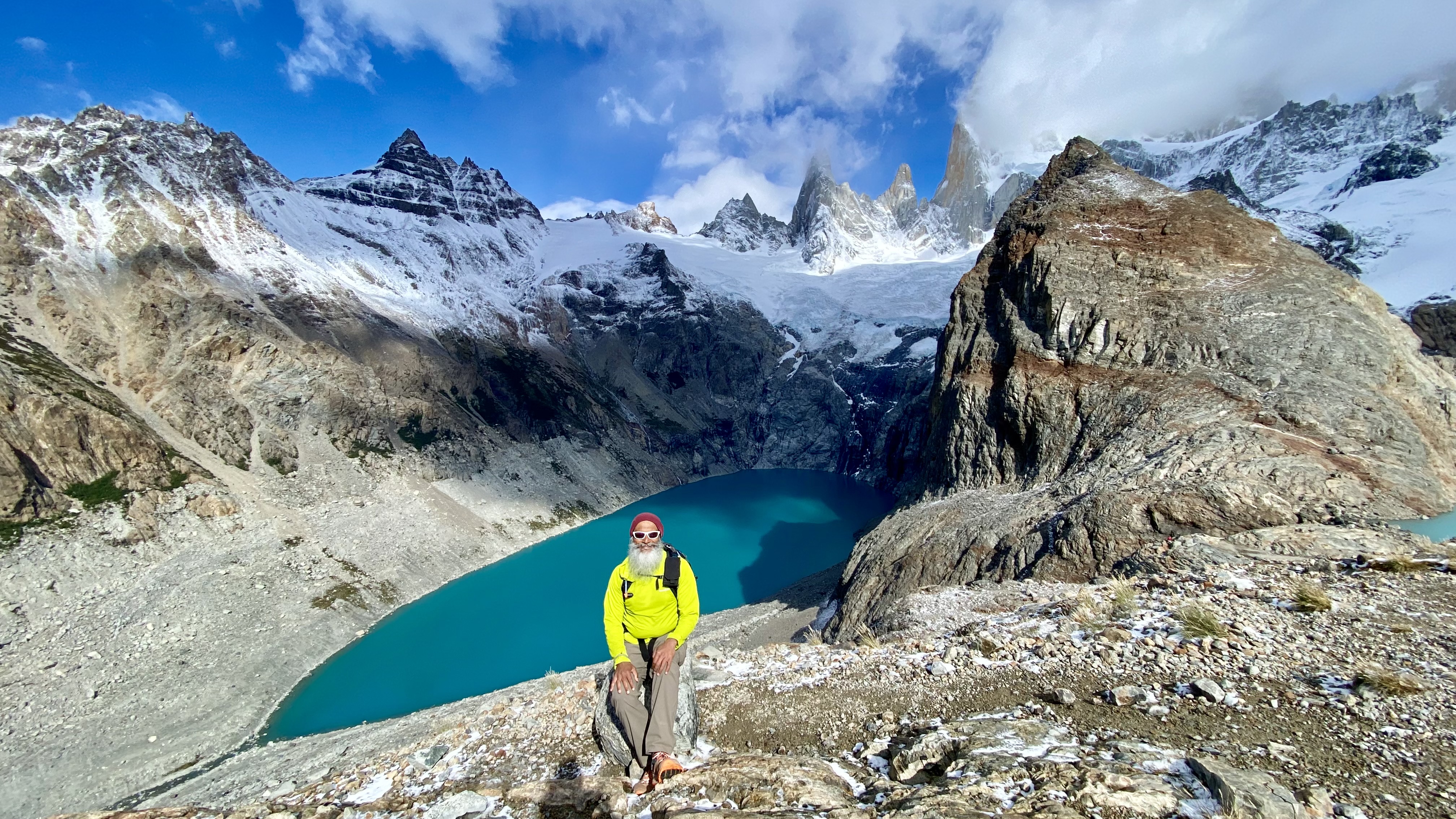 Gurpreet seated above turquoise alpine lakes beneath Fitz Roy in Patagonia